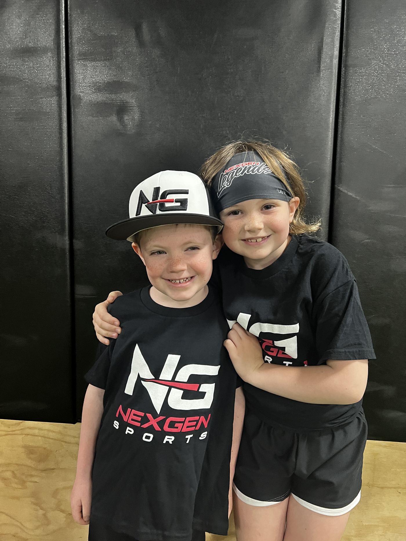 Two young NexGen athletes in team gear