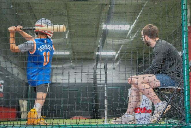 Young batter taking swings in a NexGen batting cage
