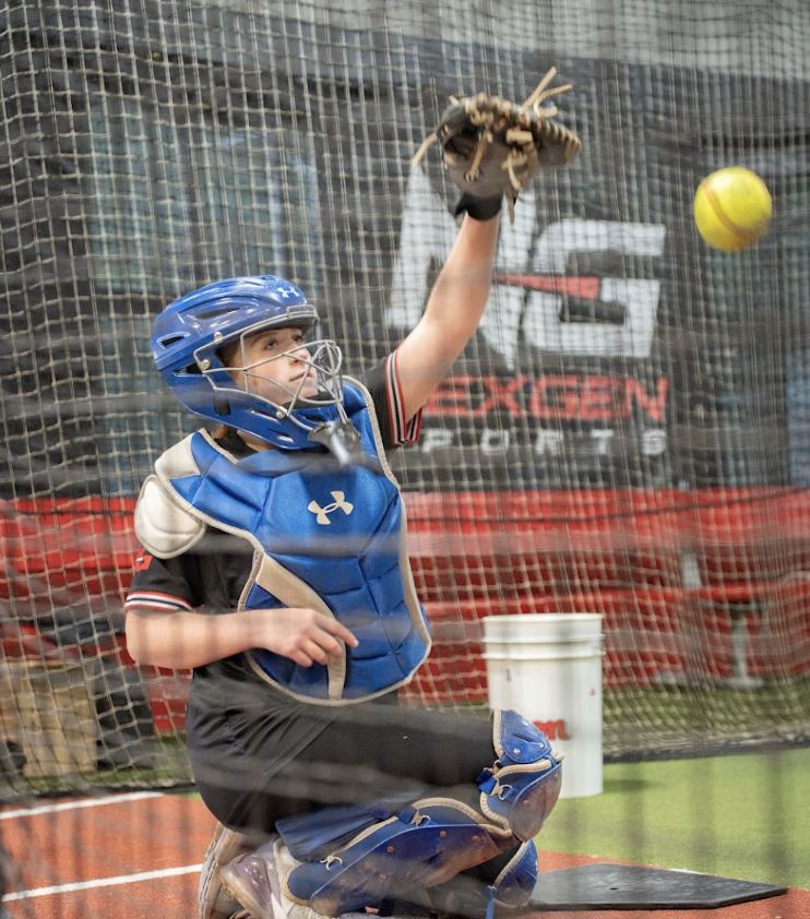 NexGen catcher framing a softball during a private lesson